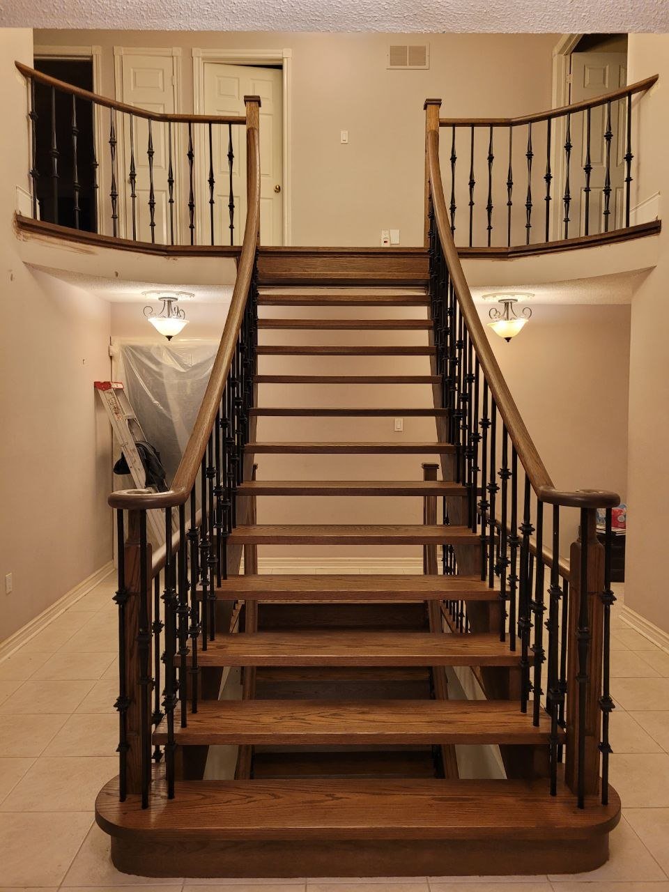 Custom oak staircase with wrought iron balusters by Mori Contracting