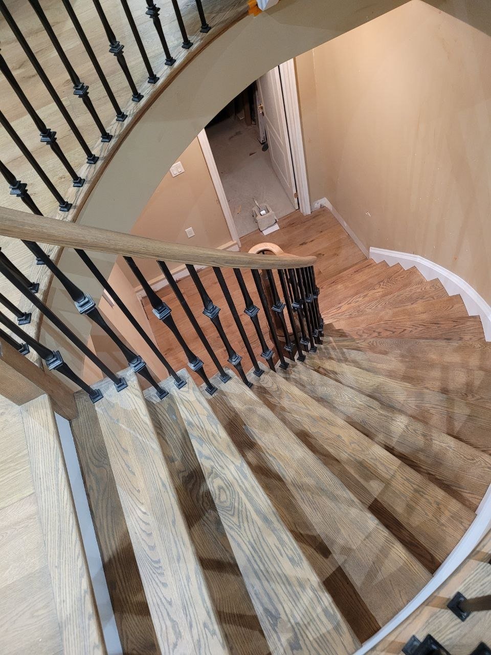 Curved oak staircase and railing, overhead view